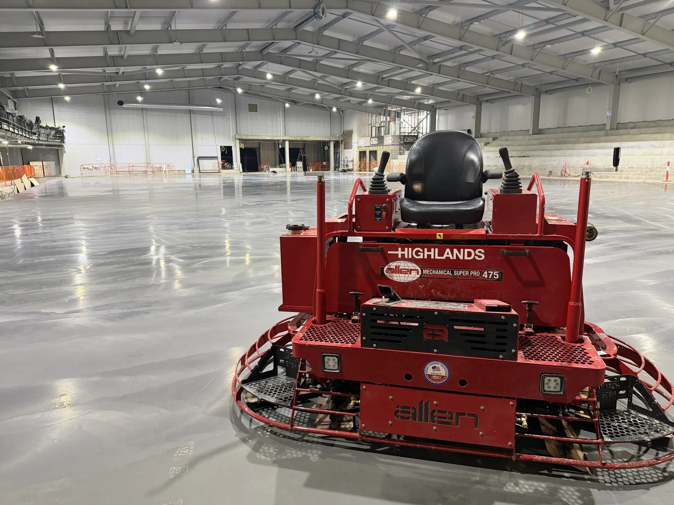 Allen Mechanical Super Pro 475 ride-on power trowel in Highlands livery, standing on the finished competition ice rink slab